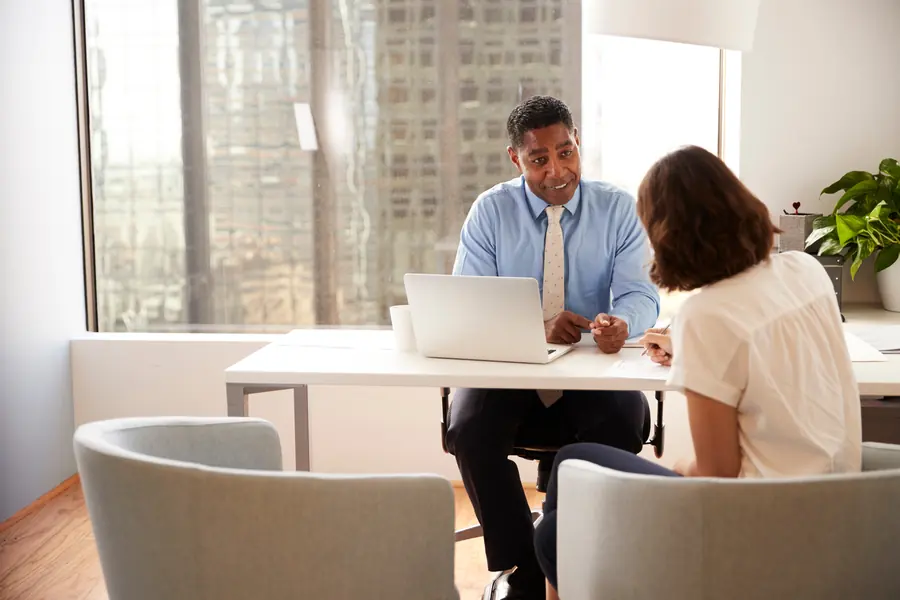 A client consultation at an advisor's desk in a bright office