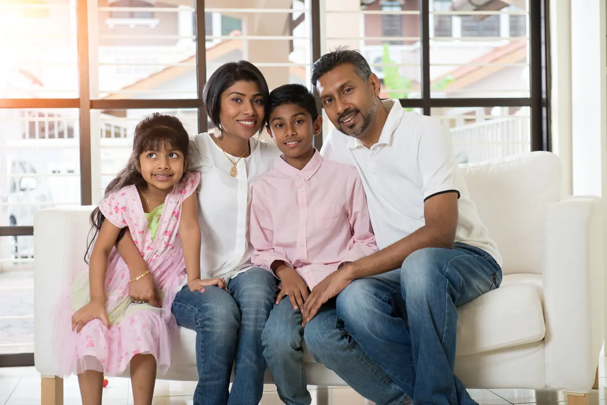 A family of four sitting together at home