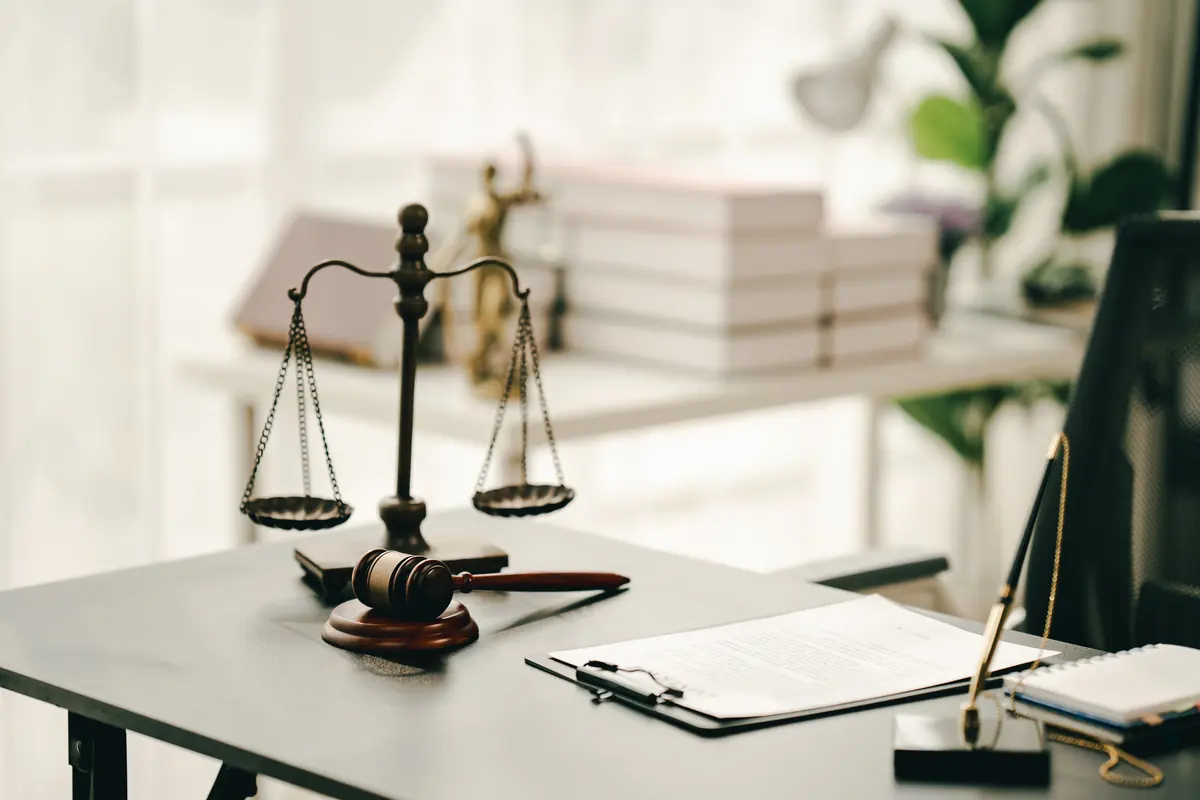 Scales of justice and a gavel on a desk in a law office